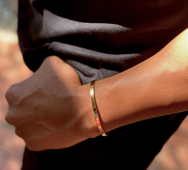 man wearing open stainless steel bangle on his wrist 